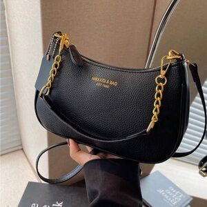 A black shoulder bag with golden writing